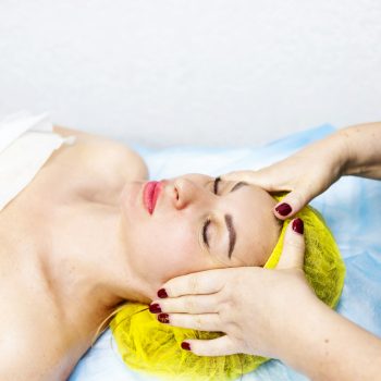 Young woman getting spa treatment with head massage at a spa center